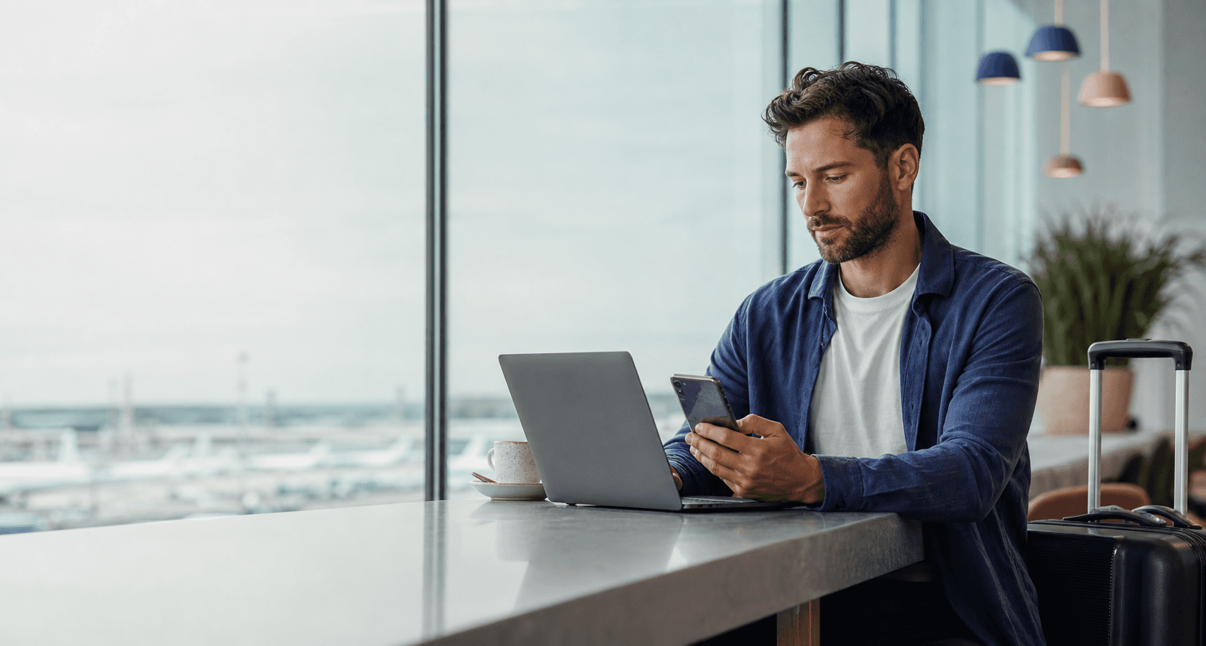 Reise-Creator arbeitet am Flughafen mit Smartphone und Laptop